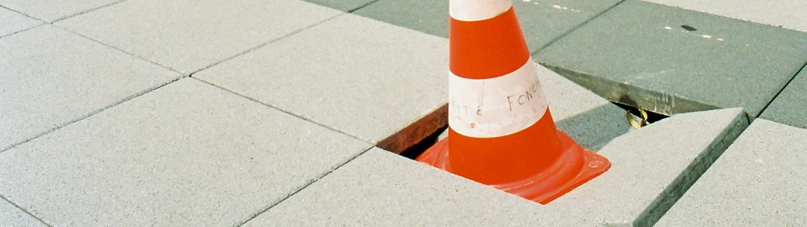 Cone in damaged paving slab