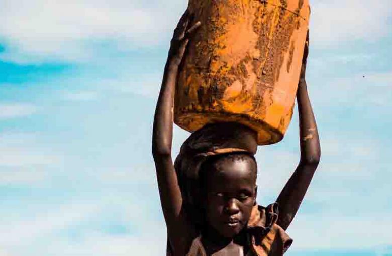 girl carrying can on her head