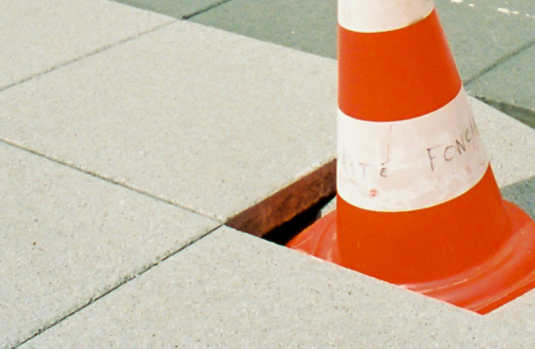 Cone in damaged paving slab