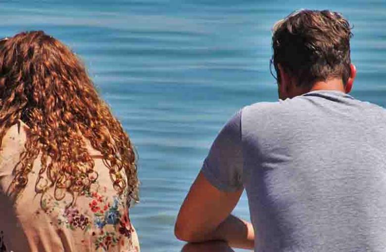 people sat looking out to sea